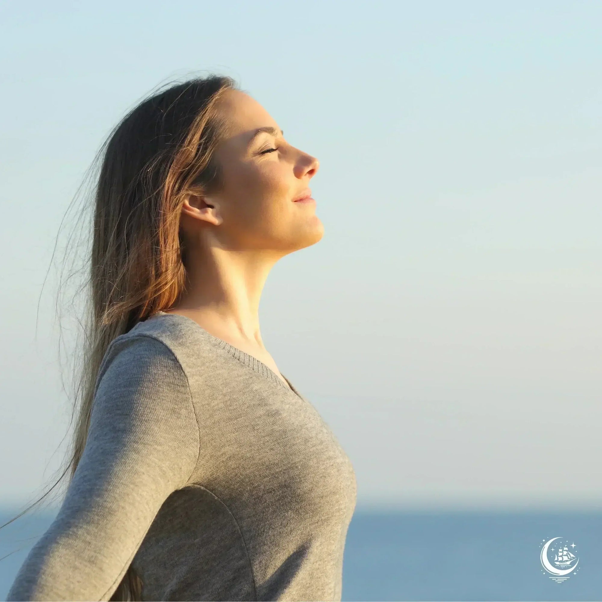 Frau geniesst tiefes Einatmen durch die Nase an der frischen Luft, Symbol für Entspannung, Wohlbefinden und gesunde Nasenatmung.