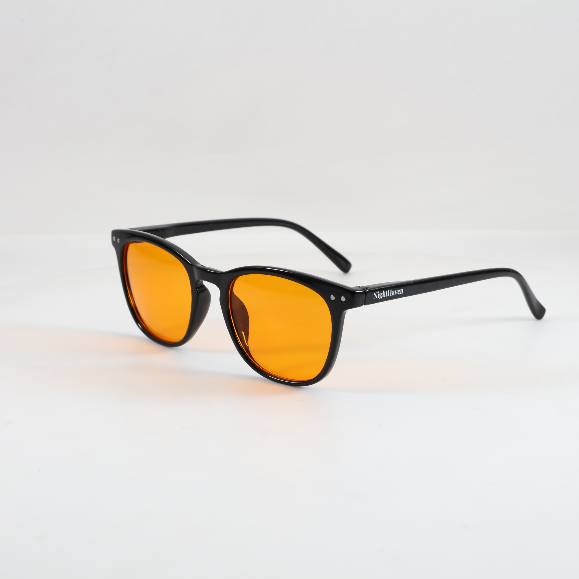 NightHaven Blaulichtfilterbrille VESPER™ Amber Lense – Schrägansicht mit schwarzem Gestell und orangefarbenen Bernstein-Gläsern für maximalen Blaulichtschutz