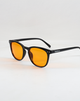 NightHaven Blaulichtfilterbrille VESPER™ Amber Lense – Schrägansicht mit schwarzem Gestell und orangefarbenen Bernstein-Gläsern für maximalen Blaulichtschutz