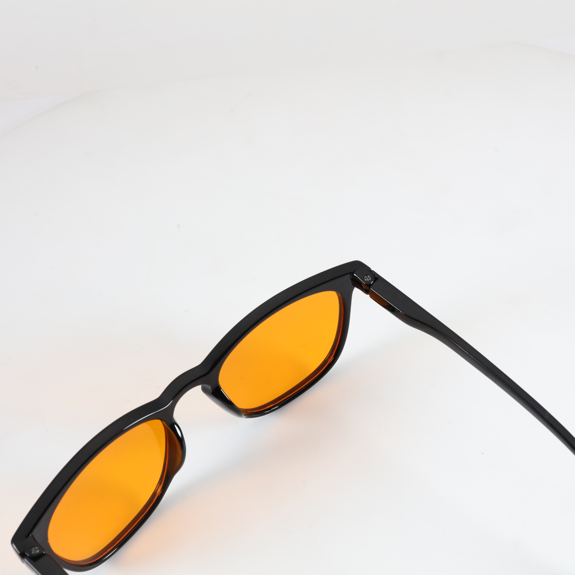 Draufsicht NightHaven VESPER™ Amber Lense – Nahaufnahme des glänzend-schwarzen Rahmens mit orangen Blaulichtfilter-Gläsern
