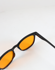 Draufsicht NightHaven VESPER™ Amber Lense – Nahaufnahme des glänzend-schwarzen Rahmens mit orangen Blaulichtfilter-Gläsern