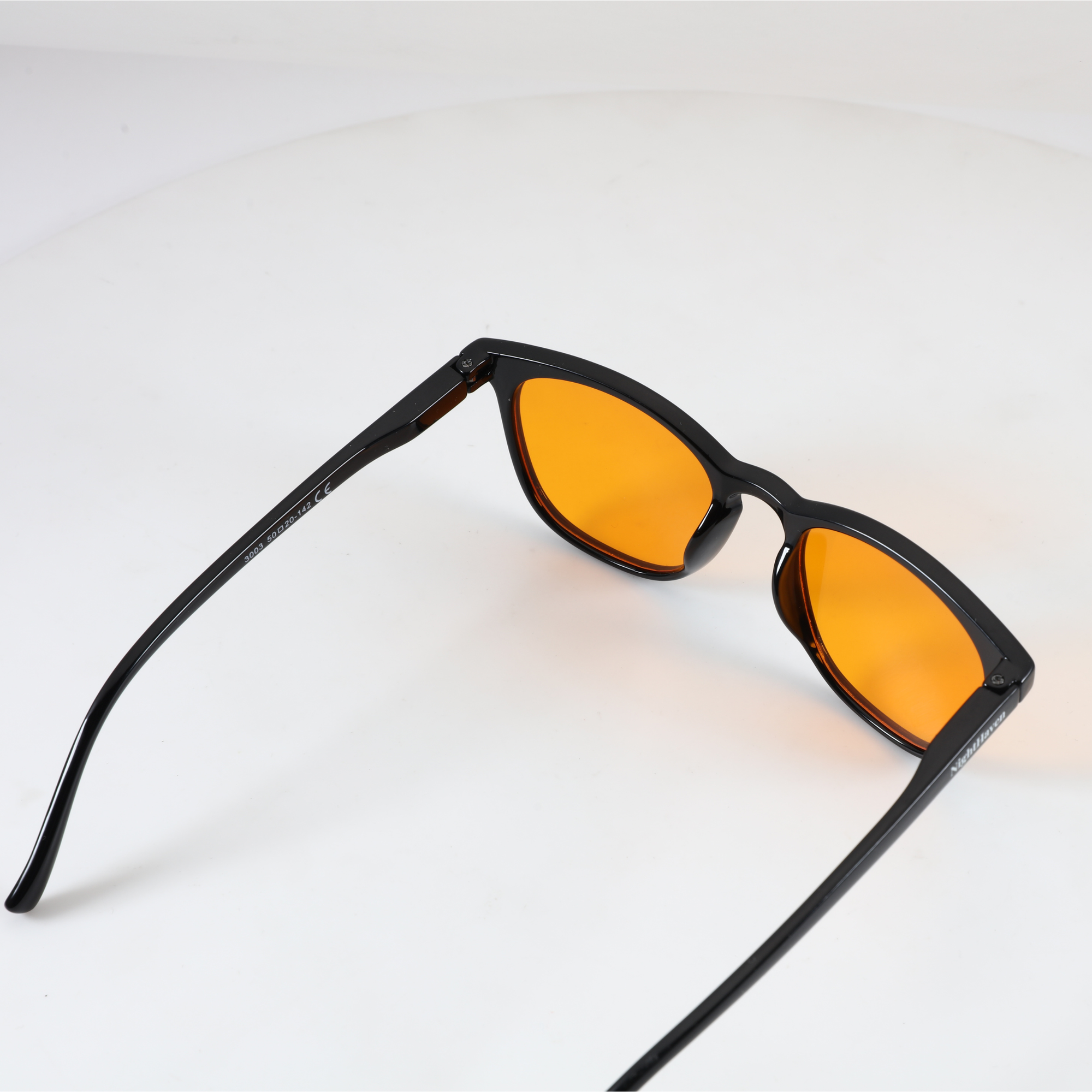Innenansicht NightHaven VESPER™ Amber Lense – Blaulichtfilterbrille mit schwarzem Hochglanz-Gestell, CE-Kennzeichnung und NightHaven-Logo auf dem Bügel